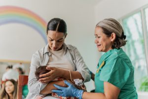 Mature woman learning to breastfeed her daughter in support group