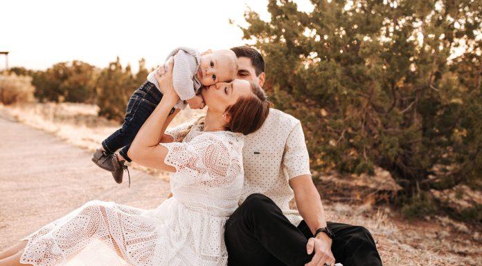 Get Your Family on Board for Photos :: A Pro Photographer’s Tricks Mom lifting up baby while dad watches behind